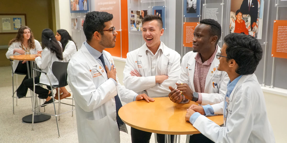 Homepage banner photo of students conversing at a table