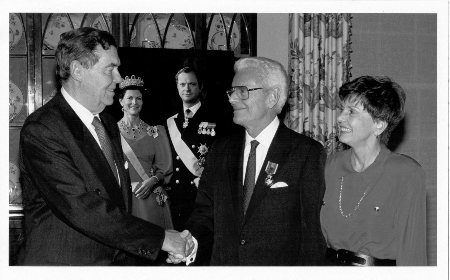 Dr. McGovern receiving the Royal Medallion of the Polar Star awarded in Houston by unidentified representative with the King and Queen of Sweden Award (pictured in the background)